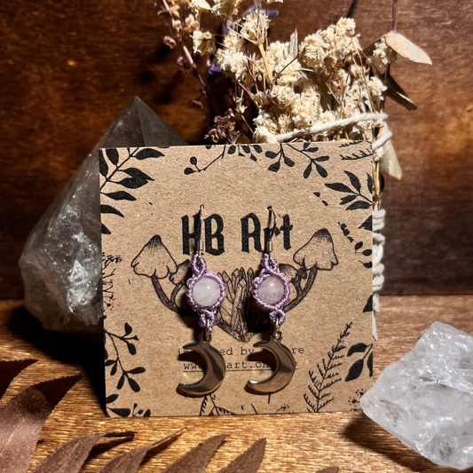 Pair of earrings on a branded card with decorative elements on a wooden surface